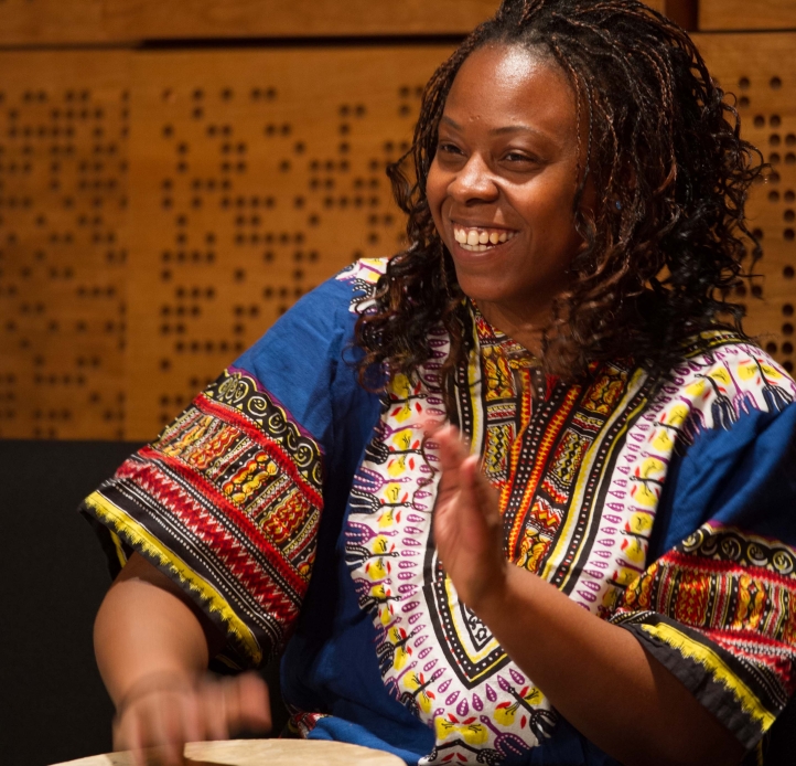 Student playing African drum